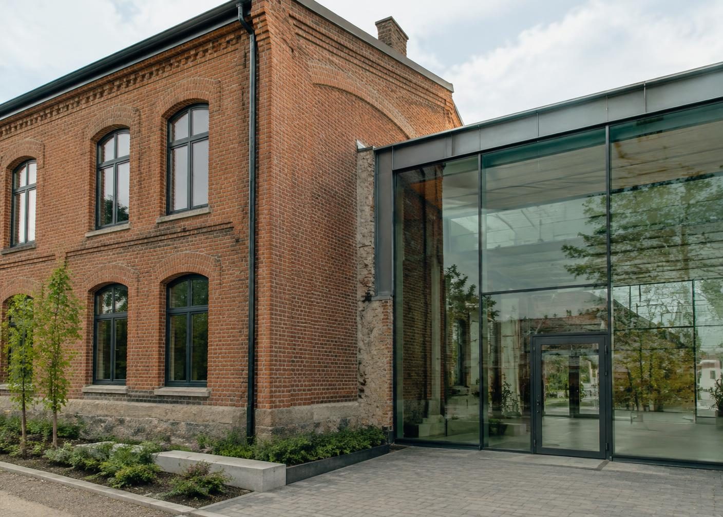 Original brick commercial architecture joined to a modern glass extension.